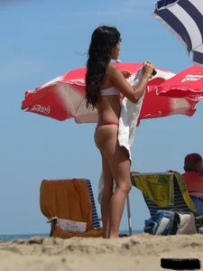 Hot brunette ethnic girl on the beach in a pink thong bikini