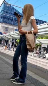 Skinny blonde in jeans on a tram stop street creepshot