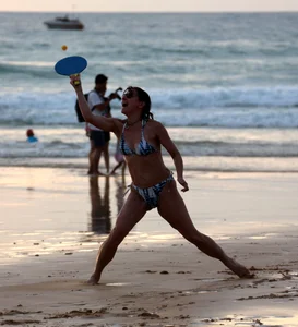 Older lady playing on the beach in her bikini