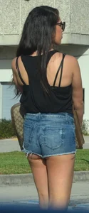 Brunette in short denim shorts showing a little cheek