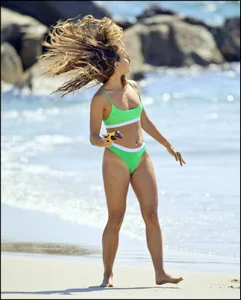Super hot beach babe with a perfect body in a green thong bikini