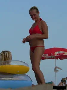 Sexy mom and daughter in red thongs at the beach