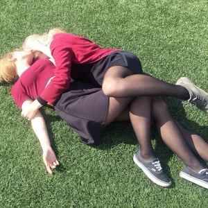 Girls Lying on the Grass in a Park Hugging
