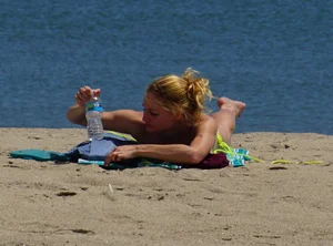 Sexy ass blonde milf on the beach in a thong with cameltoe and bending over