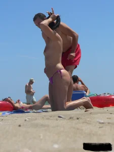 Purple thong topless lady on the beach gets oiled up by her husband
