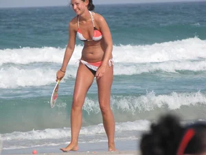 Skinny and sexy lady in a bikini playing on the beach