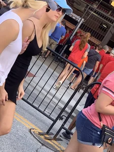 Bunch of girls in various outfits at a Cardinals baseball game