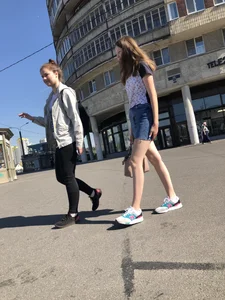 Cute Girl in a Short Denim Skirt Walking on a Street And Waiting on a Crosswalk Gallery