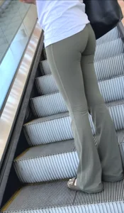 Brunette in yoga flare going up escalator