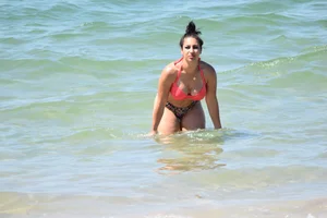 Huge boobed thick brunette babe on the beach in a bikini
