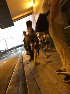 Cute Teen in Shorts on the Tram Stop