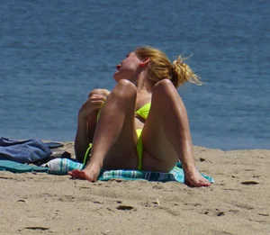 Sexy ass blonde milf on the beach in a thong with cameltoe and bending over