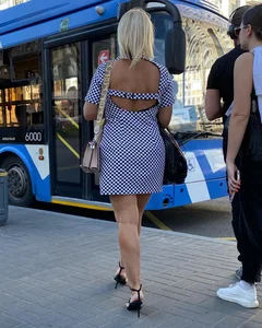 Candid hot blonde milf wearing high heels and red nail polish while showing sexy legs in short dress