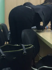 Candid college teen wearing tight black jeans bending over desk in class creepshot