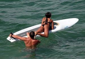 Black girl on the beach in a bikini with an incredible ass while surfing