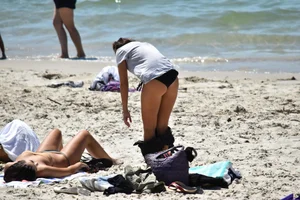 Sexy girl undressing to her bikini on the beach with an amazing body