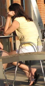Lady in flop flops while eating showing her feet