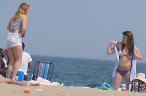 Cute girls in light blue and purple bikinis on the beach