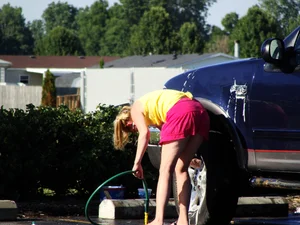 Group of cute girls at a car wash in bikinis and shorts