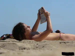 Topless beach milf looking sexy in a tiny g-string bikini