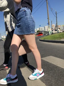 Cute Girl in a Short Denim Skirt Walking on a Street And Waiting on a Crosswalk Gallery
