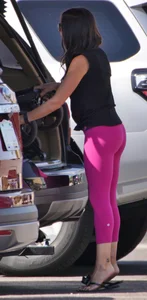 Milf brunette in purplish-pink leggings looking sexy in the parking lot