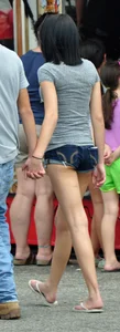 Skinny brunette in tiny denim shorts showing a little cheek