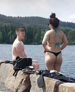 Thick brunette at the lake in a black thong bikini