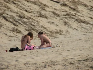 Topless beach girl with nice titties with her friend in a bikini