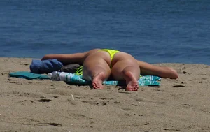 Sexy ass blonde milf on the beach in a thong with cameltoe and bending over