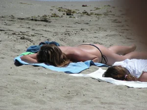 Topless girl with tan lined tits and in a black thong bikini