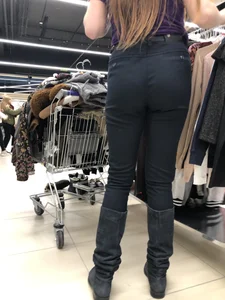 Cute candid shop assistant wearing boots and tight pants