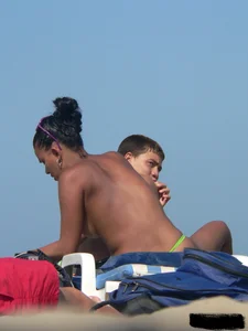 Hot ass topless beach girl with great tits lets her little brother oil up her ass in thong bikini