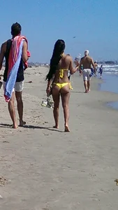 Beach babe with a nice ass and big tits in yellow thong bikini
