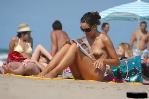2 topless girls at the beach in thongs
