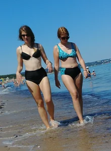 2 sexy friends in bikinis walking on the beach