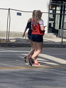 Bunch of girls in various outfits at a Cardinals baseball game