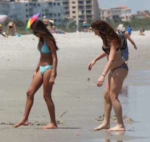 Brunette and redhead on the beach in bikinis looking sexy