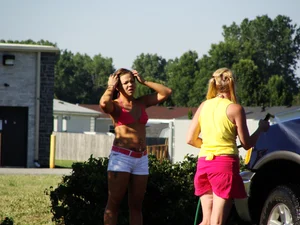 Group of cute girls at a car wash in bikinis and shorts