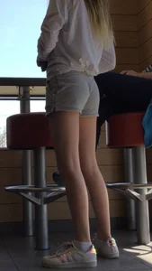 Gorgeous teen in shorts in a cafe