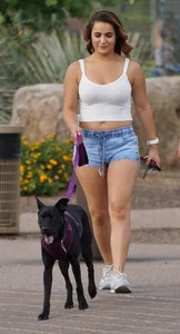 Sexy dog walker in shorts and tank top with friend in blue jeans