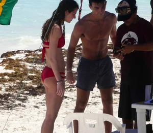 Tall sexy skinny brunette on the beach in a red bikini