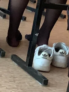 College teen's feet in black pantyhose, closeups in class