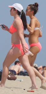 Two sexy girls in peach and pink bikinis on the beach