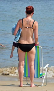 Tattooed redhead milf in a bikini at the beach