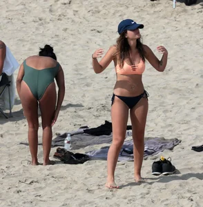 Big boobed babe with pokies in a bikini on the beach with friends