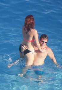 Sexy red haired girl in pink and black bikini at the pool