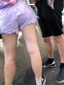 Teen legs and booty in fringed denim shorts street closeup
