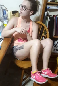 Cute Tattoed Girl Wearing Glasses Sitting at Her Home Desk