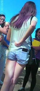 Skinny girl with purple hair in denim shorts